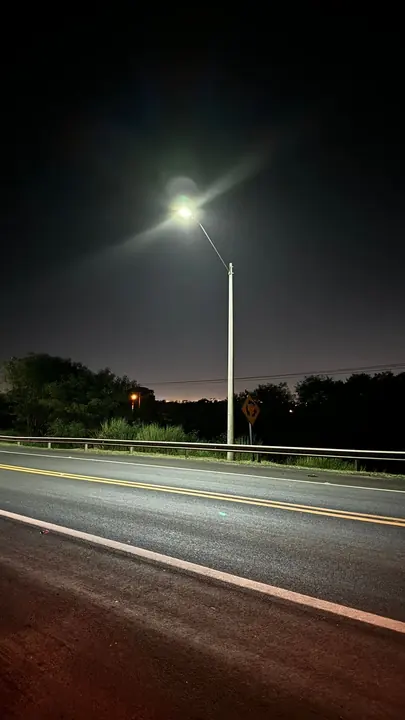 A self-powered luminaire on a pole beside the road.