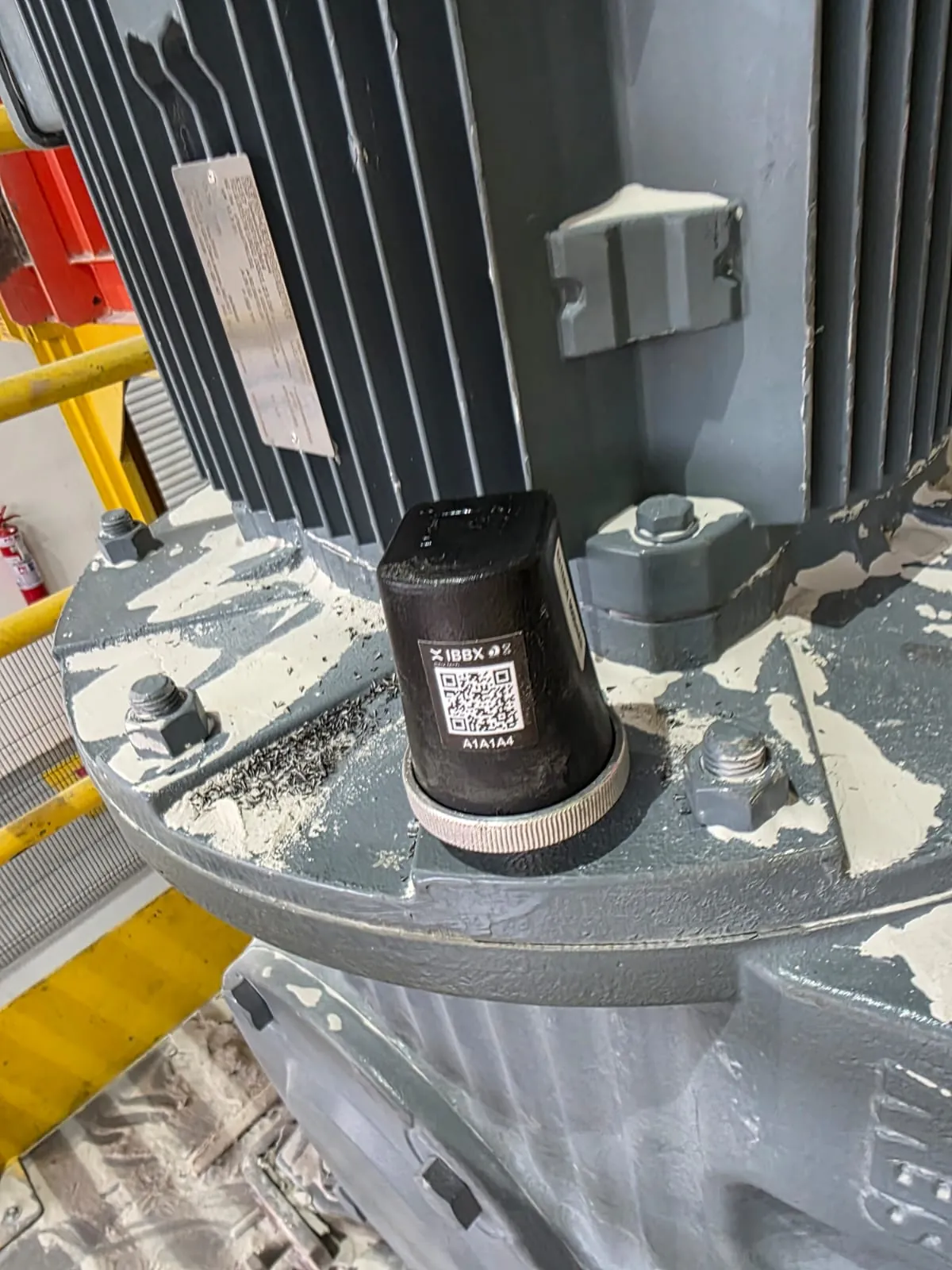 Spectra sensor mounted on the flange of a vertical electric motor.